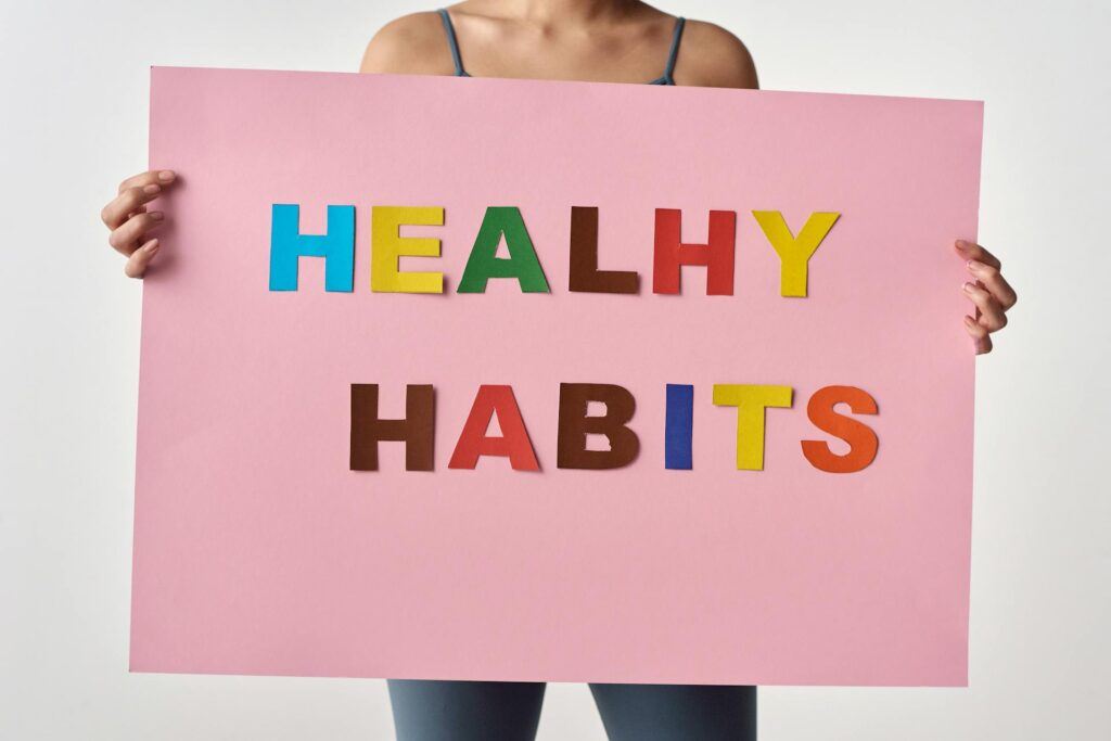 A person holding a sign with the words 'Healthy Habits' in colorful letters.